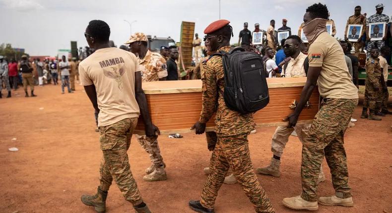 Des militaires burkinabés portent un cercueil lors de l'enterrement des 27 soldats tués alors qu'ils escortaient 207 véhicules dans un convoi à Gaskinde