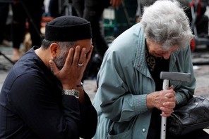 A Jewish woman named Renee Rachel Black and a Muslim man named Sadiq Patel react next to floral trib