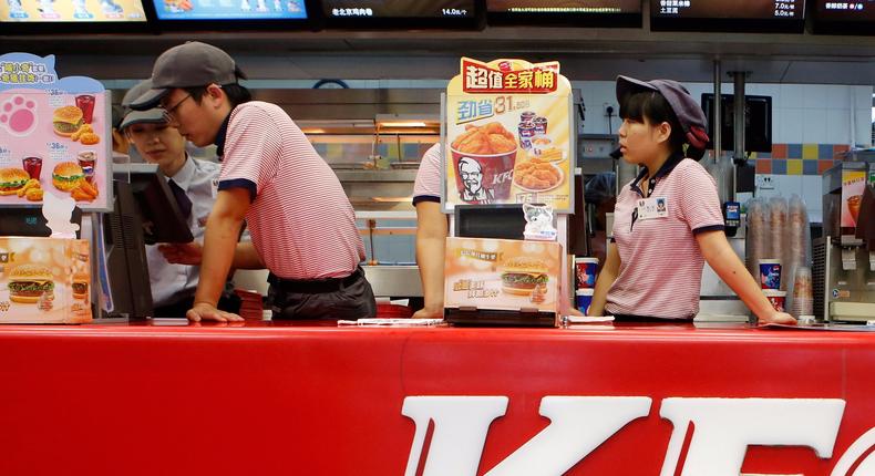 KFC's staff wait for customers at its restaurant in Beijing October 9, 2013.