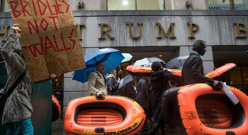 People carry rafts, signifying the struggle of refugees, as they march on Wall Street during a protest against the Trump administration's proposed travel ban and refugee policies, in New York, on March 28, 2017