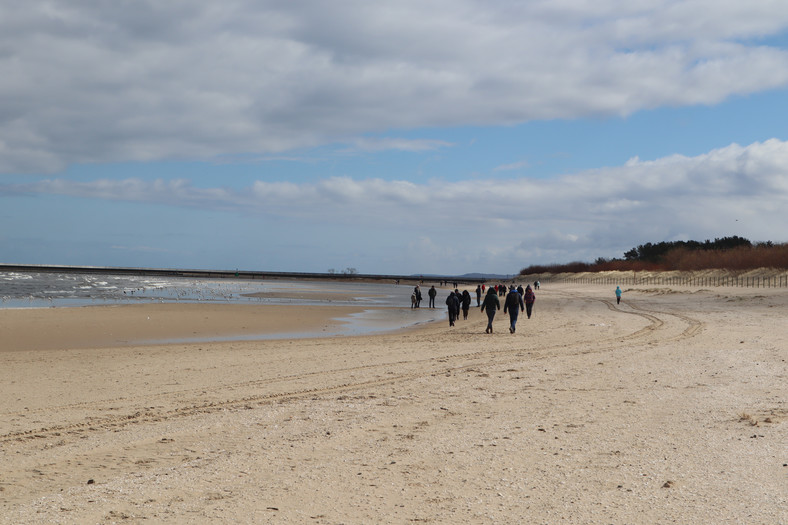 Am Strand können Sie auch in der Nebensaison Touristen spazieren sehen, Winoujście am 11. April 2022.