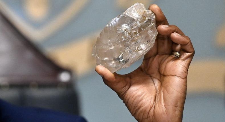 Botswana's President Mokgweetsi Masisi holds a large diamond discovered in Botswana at his office in Gaborone on August 22, 2024.MONIRUL BHUIYAN/Getty Images