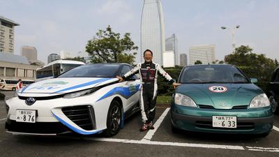 Toyota Motor Corp President Toyoda poses with the company's hydrogen fuel cell vehicle (FCV) sedan c