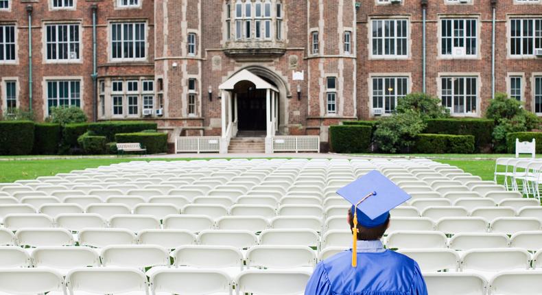 College graduate sitting outside.
