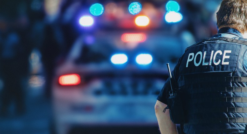 US police officer stands in front of a police car.Getty Images