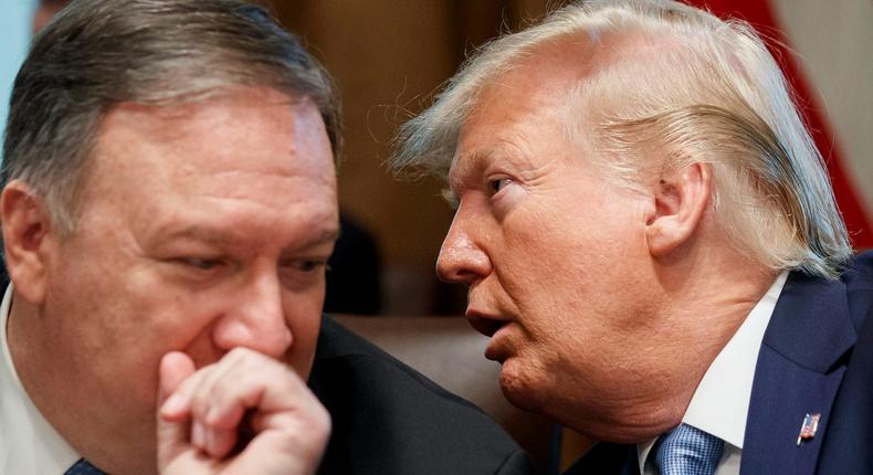 Secretary of State Mike Pompeo, left, and President Donald Trump whisper during a Cabinet meeting in the Cabinet Room of the White House, Tuesday, July 16, 2019, in Washington.