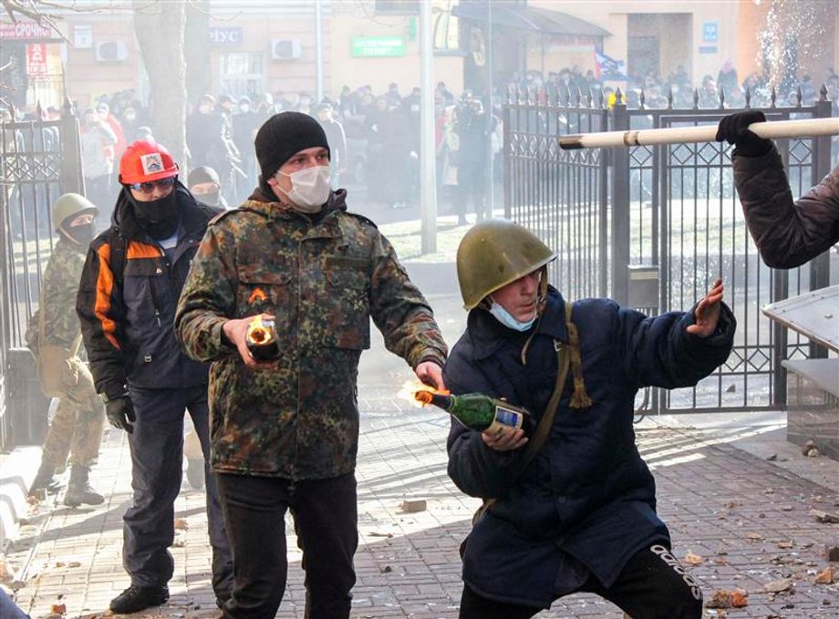 Antigovernment protesters hold Molotov cocktails as they attack an office of the pro-presidential Party of the Regions in Kiev.