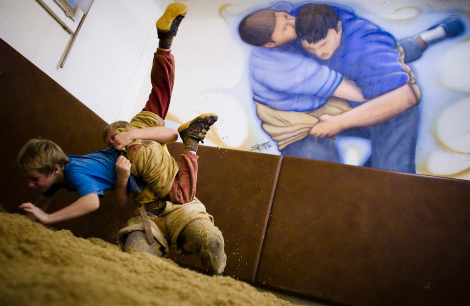 Youths practice traditional Swiss Alpine wrestling in a ring covered with sawdust at a traditional 'Schwingkeller' gym in Sumiswald