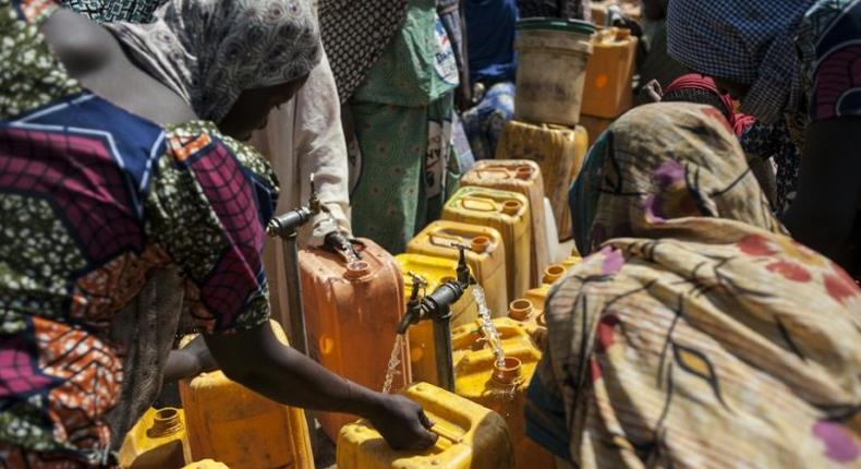 Women collect water from a water point at the Internally Displaced People (IDP) camp, in Bama, on December 8, 2016