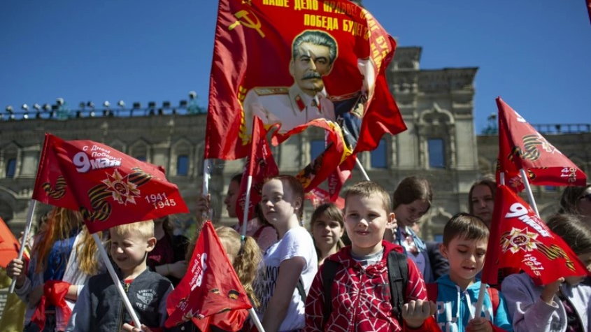 Dzieci stojące na Placu Czerwonym z flagą z portretem Józefa Stalina