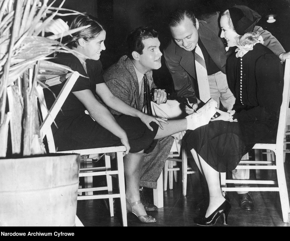 Aktorzy amerykańscy Fred MacMurray, Jack Denny  i Carole Lombard  składają autografy na ogipsowanej nodze Jadzi,  Hollywood 1937 r.