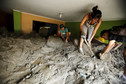People remove mud and rocks from their house after a massive landslide in Chosica