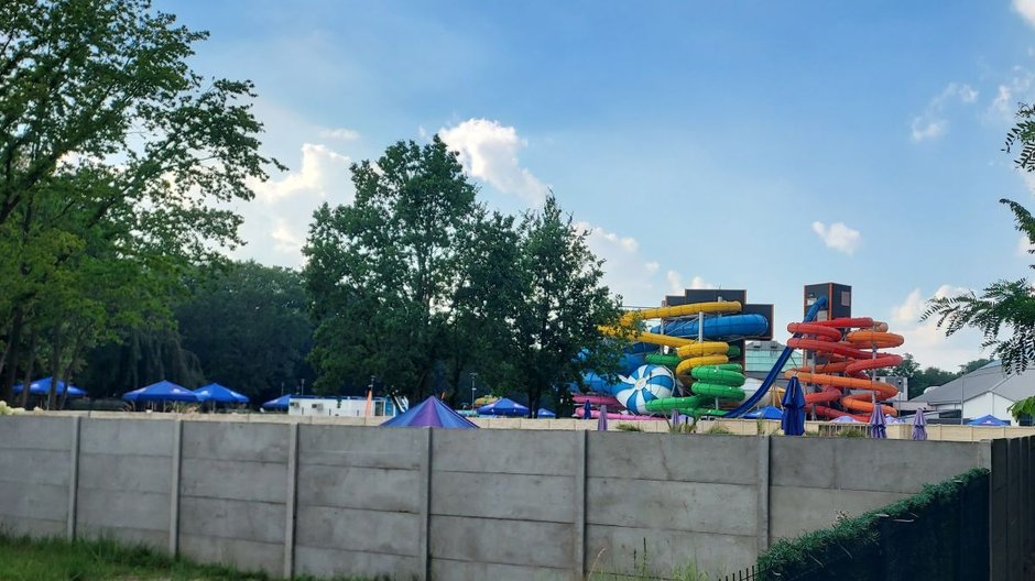 Widok na plażę nudystów zza ogrodzenia Aquaparku Fala