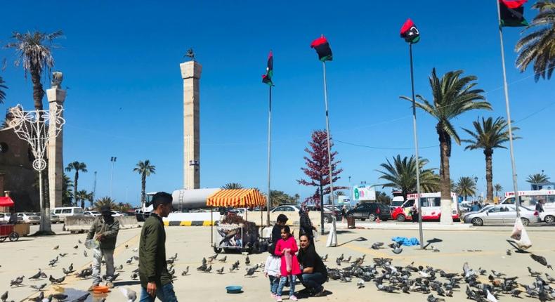 Libyans walk in the Tripoli's Martyr Square as fresh fighting flared south of the capital
