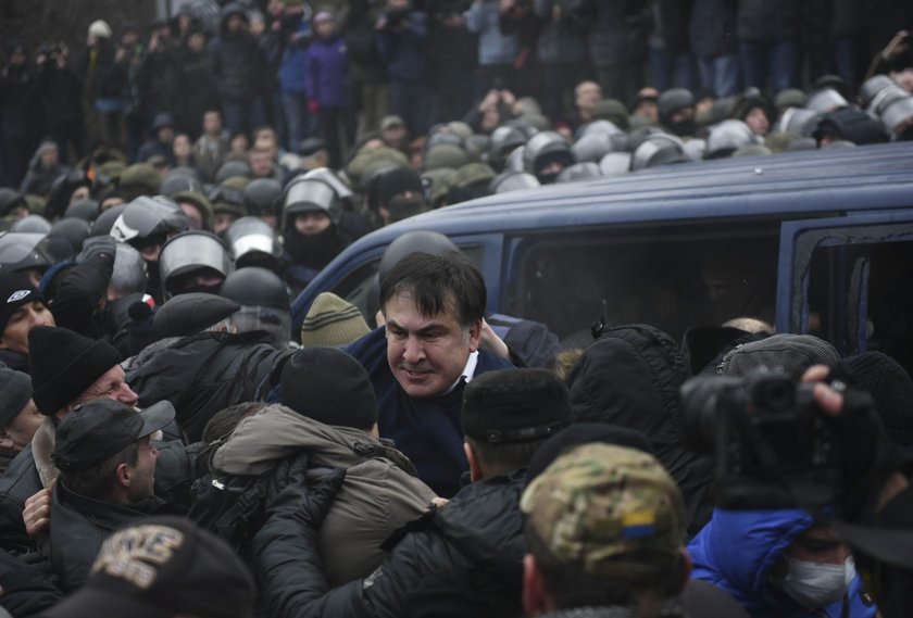 Supporters of Georgian former President Mikheil Saakashvili break a window a police car carrying Saa