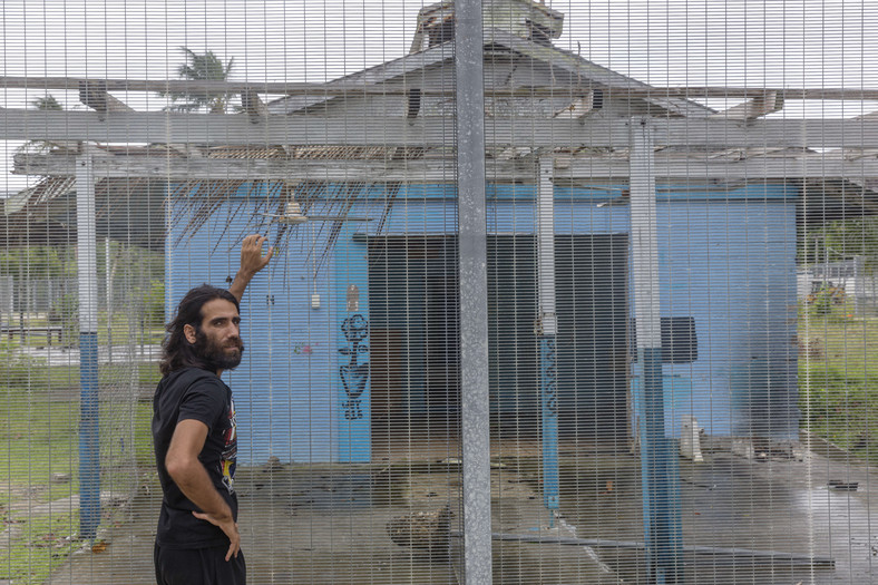 Behrouz Boochani przy bramie niedziałającego już australijskiego obozu dla uchodźców Manus Regional Processing Centre