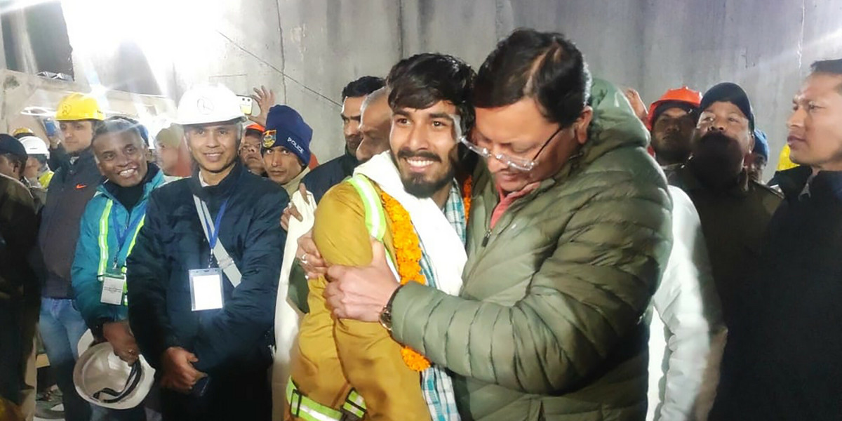Singh Dhami (z prawej), minister stanu Uttarakhand z pracownikiem uratowanym z zawalonego tunelu, 28 listopada 2023 r.