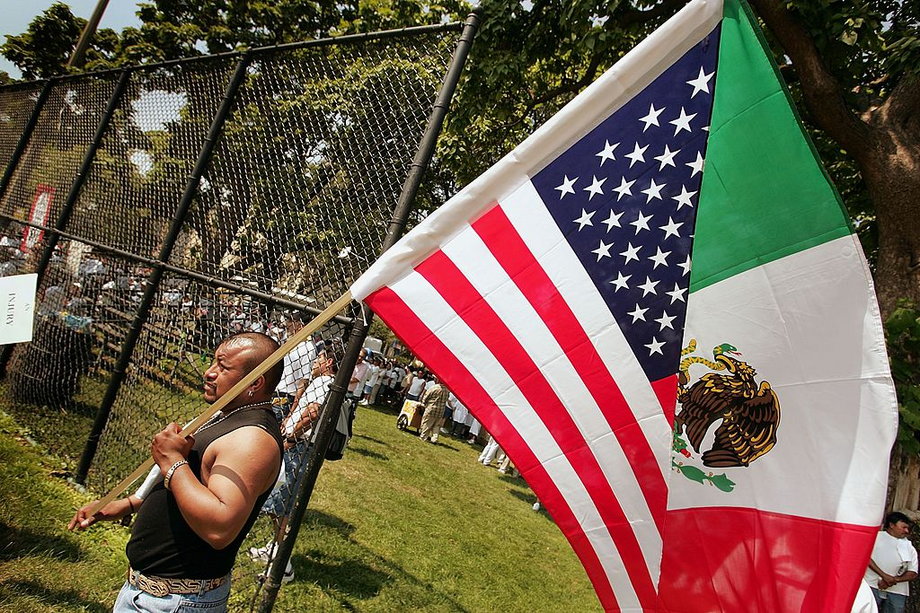 Miguel Orocio carries a half-US/half-Mexican flag during an immigrant rights march, July 19, 2006, in Chicago, Illinois.