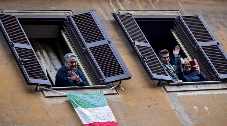 Integetnek az emberek egy római ház ablakaiból 2020. március 14-én.  / Fotó: MTI/EPA/ANSA/Angelo Carconi