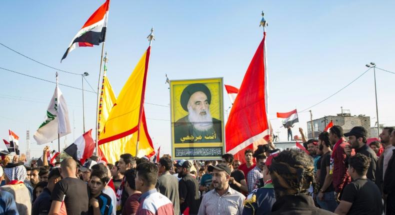 Demonstrators in Iraq's main southern city of Basra hold aloft a portrait of Shiite spiritual leader Grand Ayatollah Ali Sistani, who has increasingly backed their cause