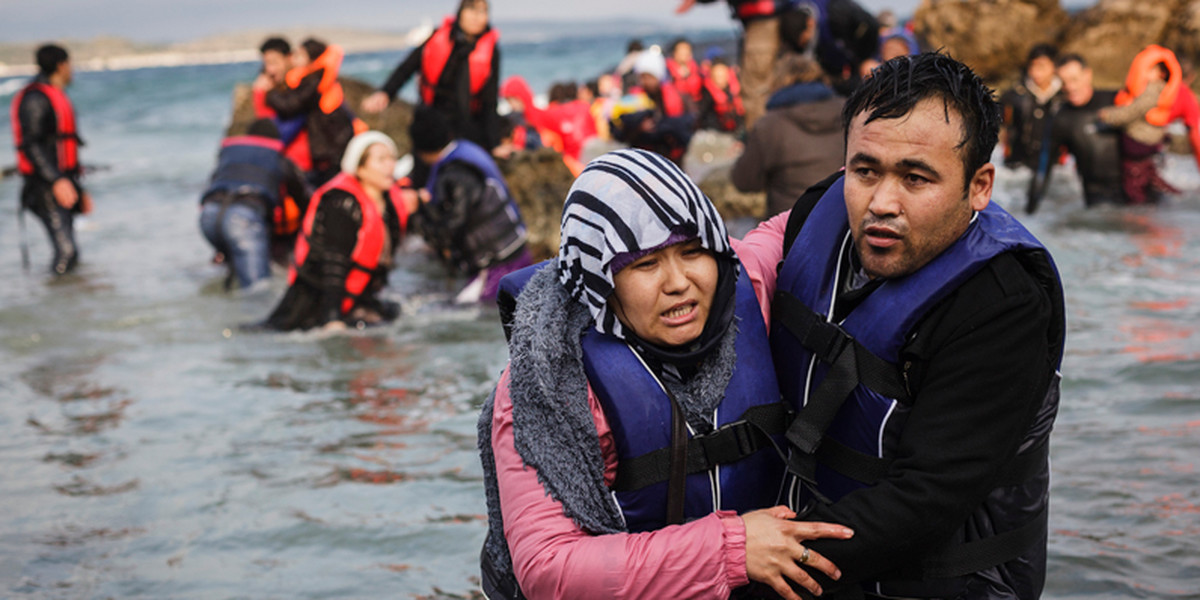 Uchodźca z Afganistanu pomaga swojej żonie wyjść na brzeg greckiej wyspy Lesbos. Styczeń 2015.