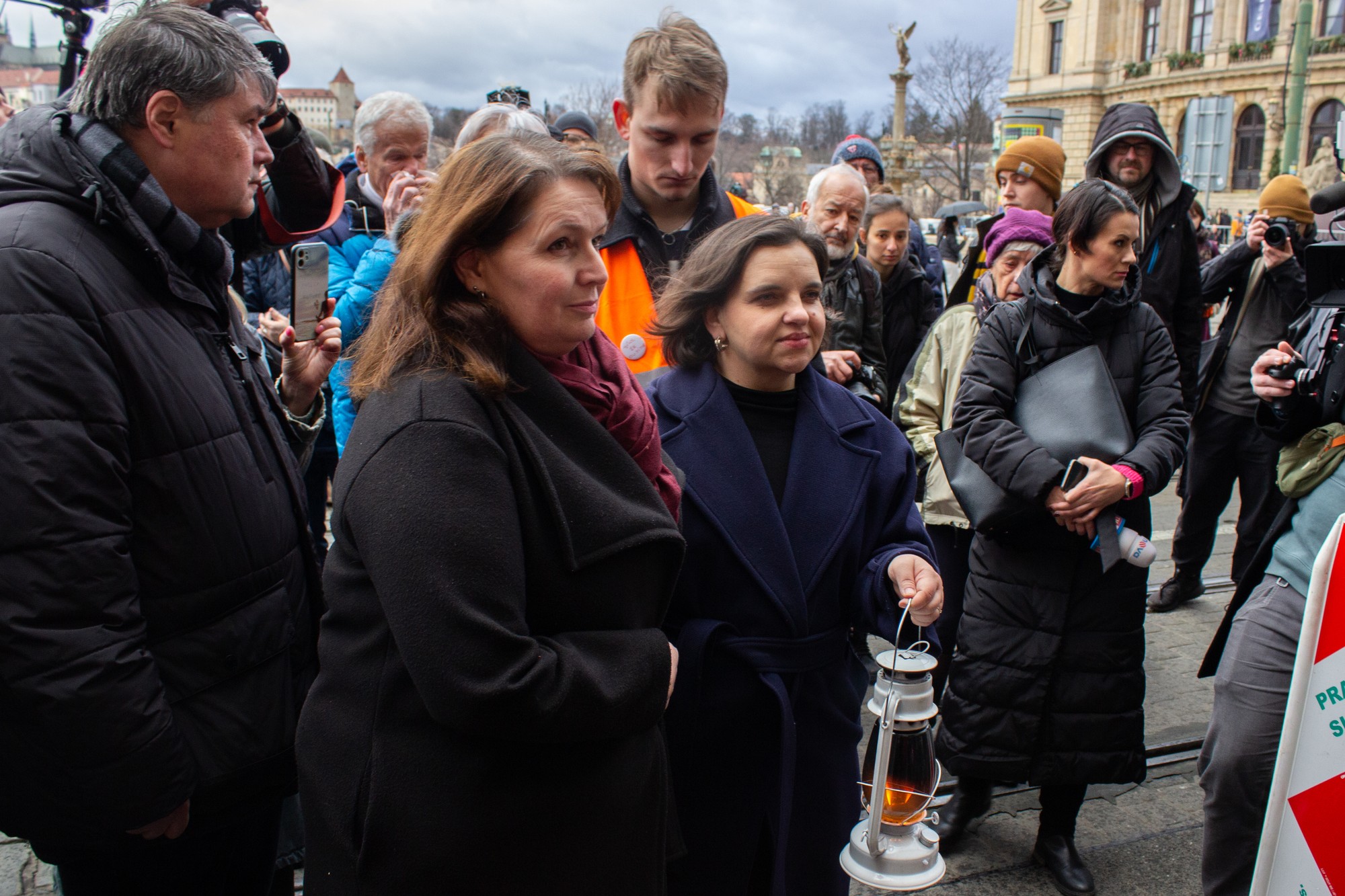 Na snímke vľavo rektorka Univerzity Karlovej (UK) Milena Králíčková a vedľa nej dekanka Filozofickej fakulty (FF) UK Eva Lehečková symbolicky preniesli oheň z pietneho miesta pri Rektoráte UK pred hlavnú budovu FF UK na Námestí Jana Palacha.