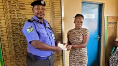 The Commissioner of Police, Kaduna State Command, Mr Musa Garba presenting cheque to a deceased police officer’s  family member, in Kaduna (Credit: NAN)