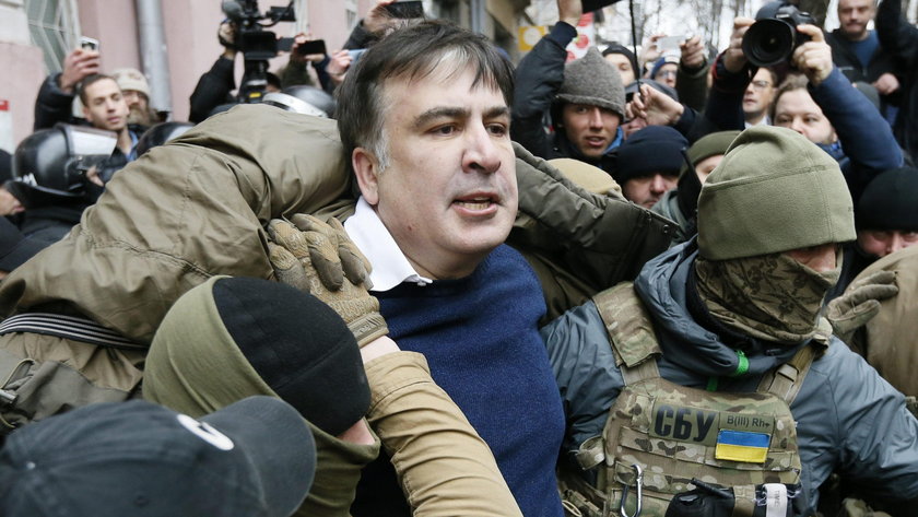 Supporters of Georgian former President Mikheil Saakashvili break a window a police car carrying Saa