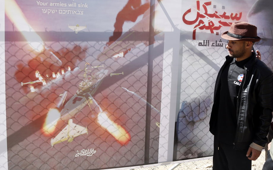 Mężczyzna patrzy na billboard z wizualizacją rakiet celujących w statki w dniu, w którym siły dowodzone przez Jemen Huti obrały za cel amerykański statek na Morzu Czerwonym. 10 stycznia 2024 r.
