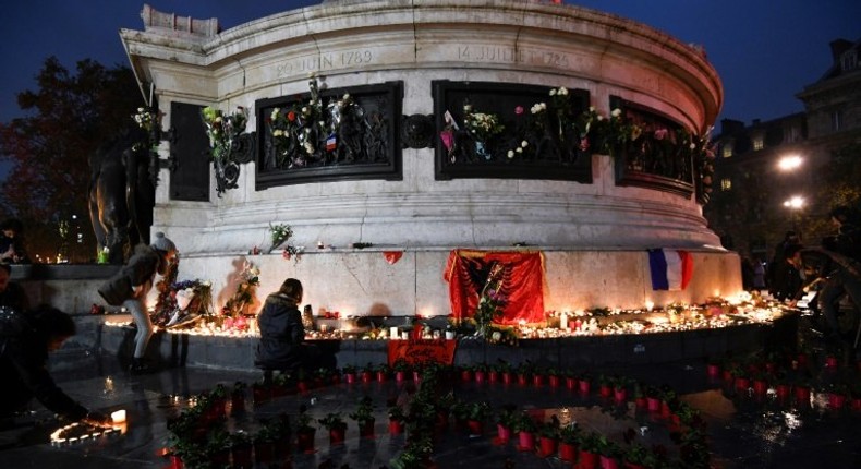 People light candles at a makeshit memorial at the bottom of the Marianne statue on place de la Republique in Paris on November 13, 2016