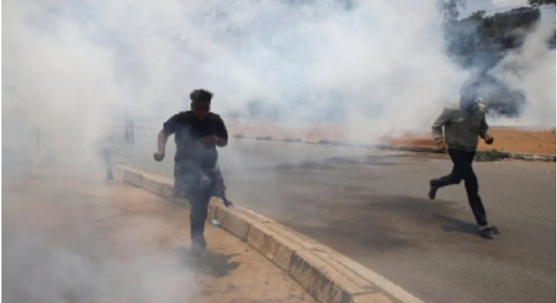 Kenyan police enforcing lock-down take to their heels as residents chase them up with teargas