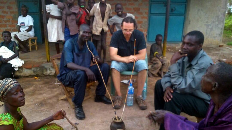 Damian Małaszewski pijący proso w Ugandzie