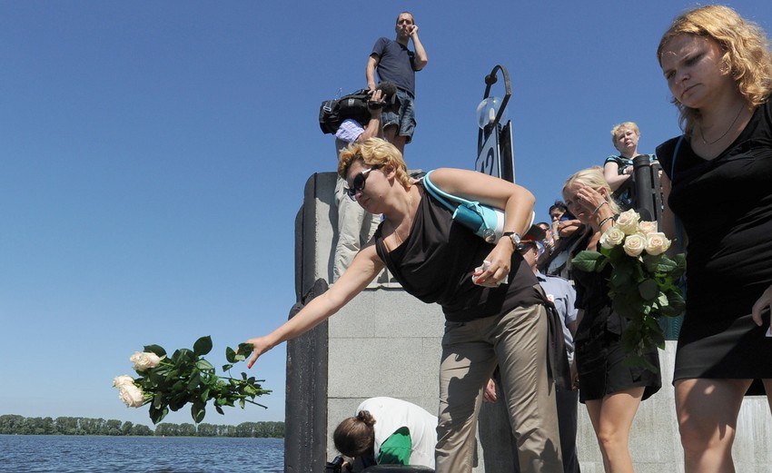 Ljudi bacaju cveće u Volgu gde je potonuo brod