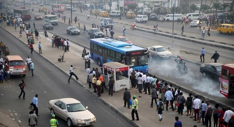 People queue as they wait for a commercial bus during the morning rush hour in Ojota district in Nigeria's commercial capital Lagos November 23, 2015. 