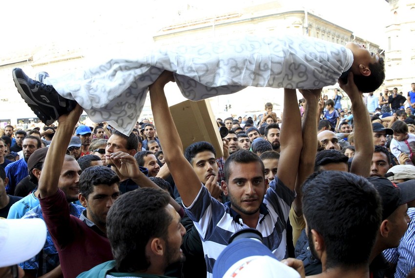 Dečaka umotanog u ćebe drže na rukama na današnjem protestu u Budimpešti ispred železničke stanice Keleti