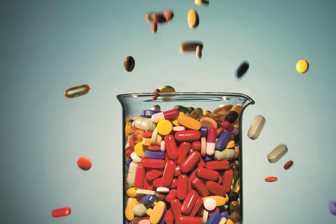 Pills Falling Into a Beaker