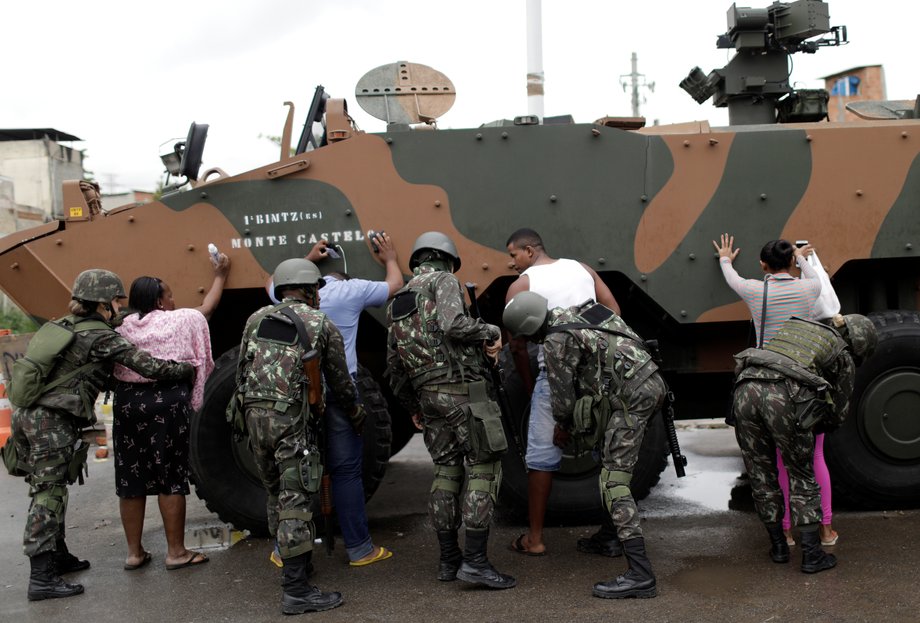 Security forces search residents during an operation against organized crime in the Manguinhos slum complex in Rio de Janeiro, August 21, 2017.