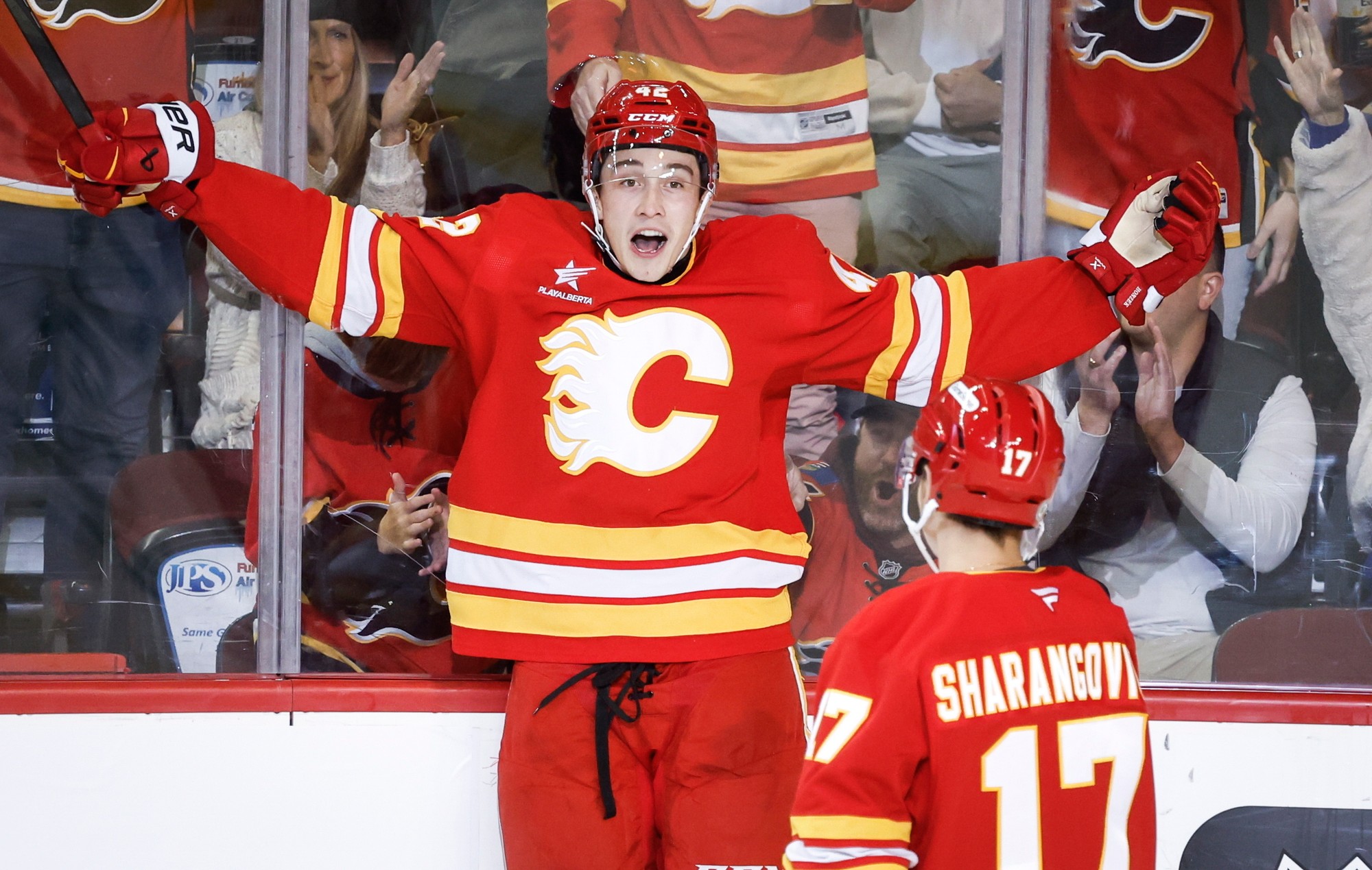 Slovenský hokejista Samuel Honzek (vľavo) a Jegor Šarangovič z Calgary Flames sa radujú z gólu.