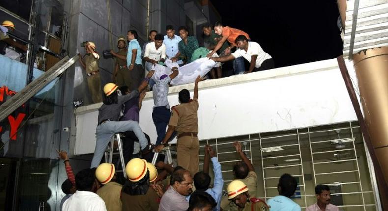 Rescue workers lower the body of a victim of a massive fire at the SUM hospital building in Bhubaneswar, the capital of eastern India's coastal Odisha state, on October 17, 2016