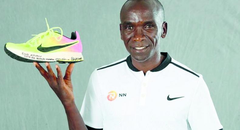 Eliud Kipchoge with his Rio Olympic shoe which was first displayed at the 2019 IAAF Heritage World Athletics Championships Exhibition in Doha, Qatar.