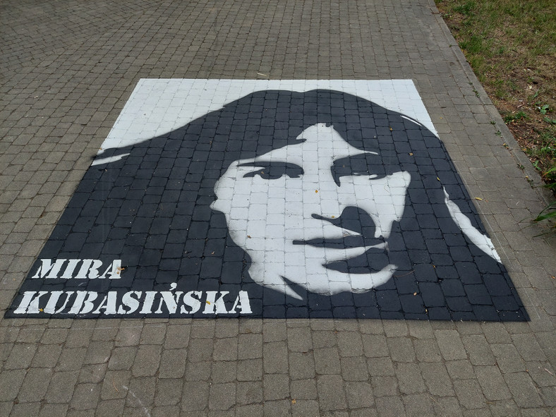 Grafika przedstawiająca Mirę Kubasińską w miejskim parku w Ostrowcu