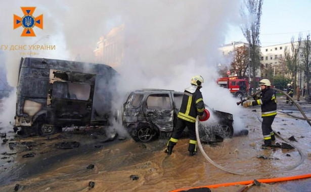 Strażacy dogaszają samochody po ataku rakietowym w centrum Kijowa,