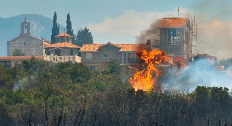 A forest fire consumes vegetation next to a monastery on the Lustica peninsula near the town of Tivat, Montenegro, on July 17, 2017