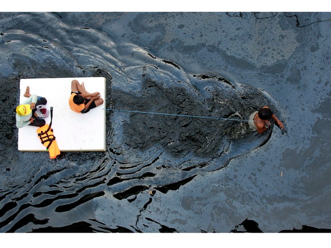 Ofiary powodzi w Don Mueang (w dystrykcie Bangkok), holowane przez zalane ulice. Październik 2011