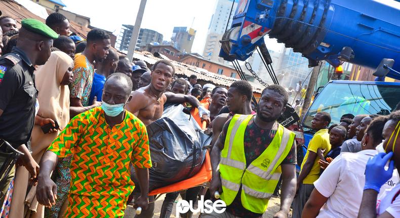 A corpse being taken away from the site of the collapsed building in Ita-Faaji, Lagos Island