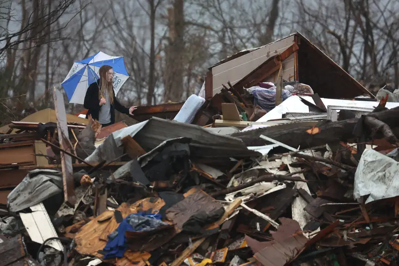 Mieszkanka Kentucky szuka pamiątek na gruzach swojego rodzinnego domu. 16 grudnia 2021 r., Dawson Springs / Getty Images