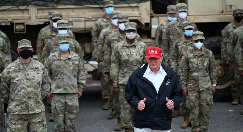 US President Donald Trump poses with National Guard troops in Lake Charles, Louisiana, on August 29, 2020 on a trip to survey damage from Hurricane Laura