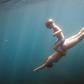 Underwater view of boy and mother diving