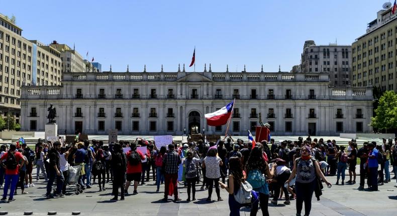 Demonstrators outside the Presidential Palace, known as La Moneda, in Santiago, Chile where President Sebastian Pinera shuffled his cabinet amid a crisis