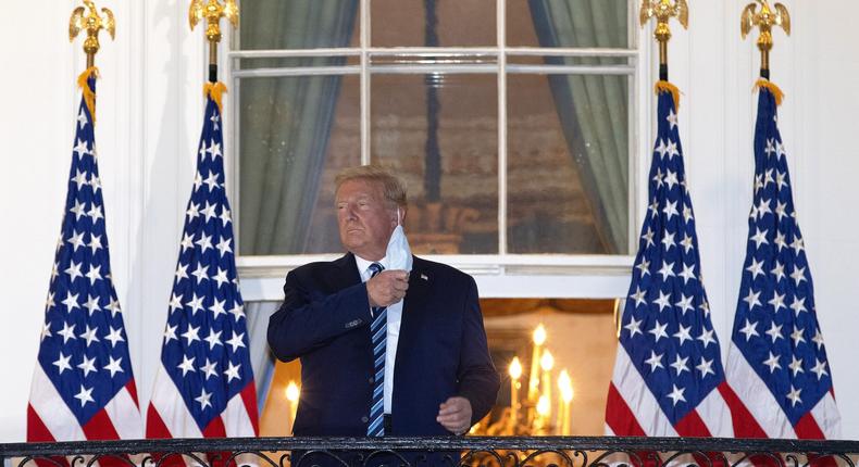 U.S. President Donald Trump removes his mask upon return to the White House